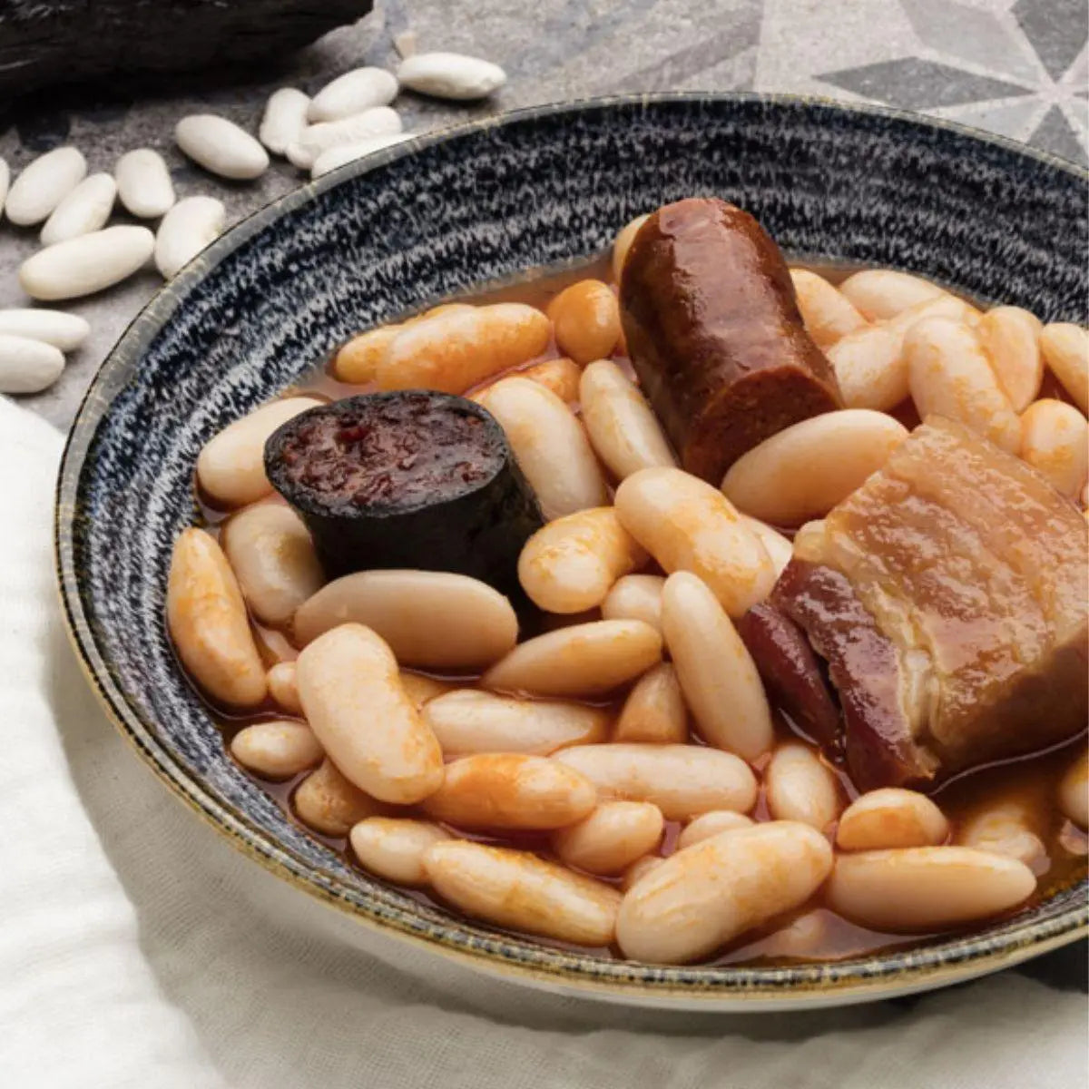 Primer plano de la morcilla, el chorizo y la faba mantecosa de la fabada asturiana conservas arbeyal.