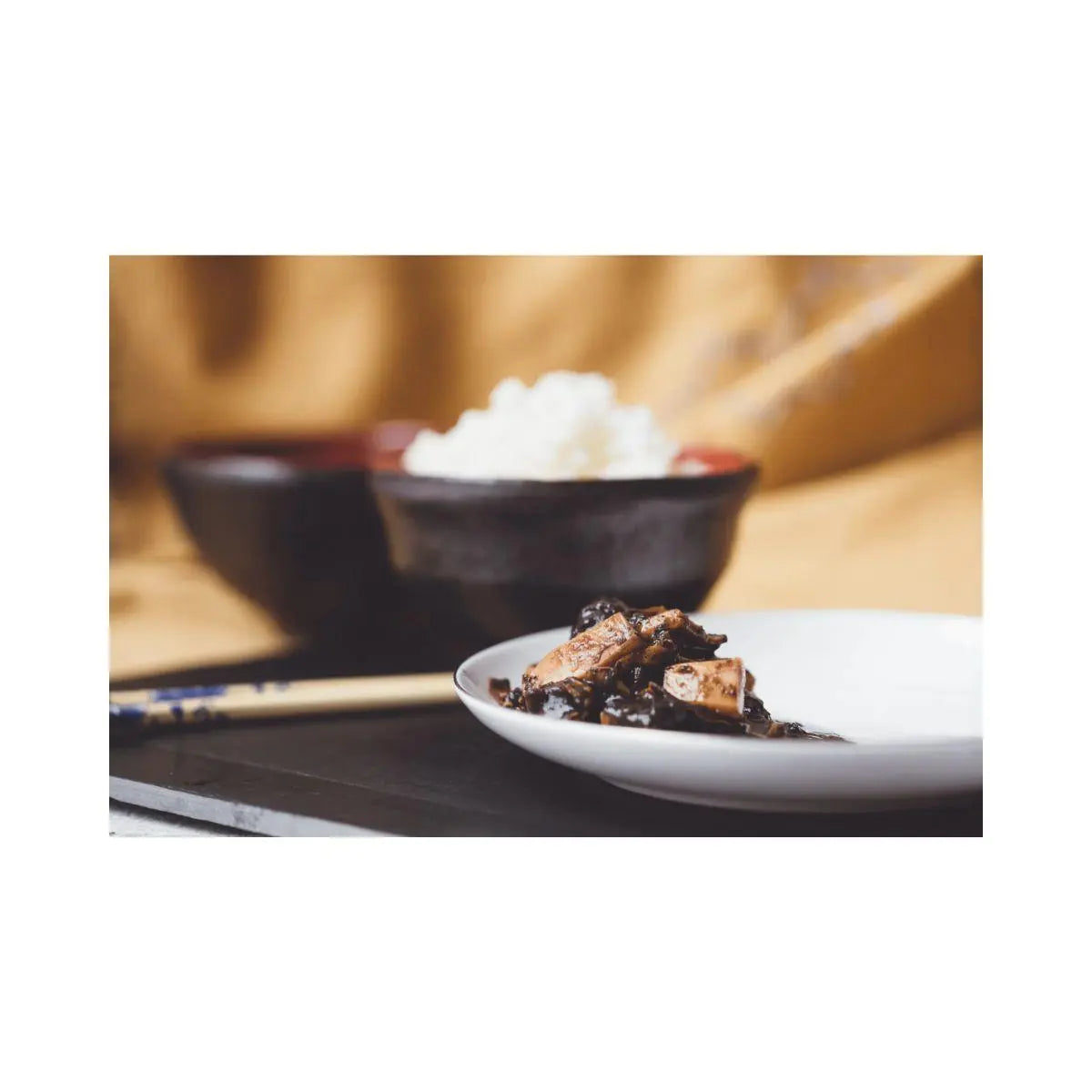 Cazuela de barro con sepia en su tinta caliente y pan artesano para mojar la salsa.